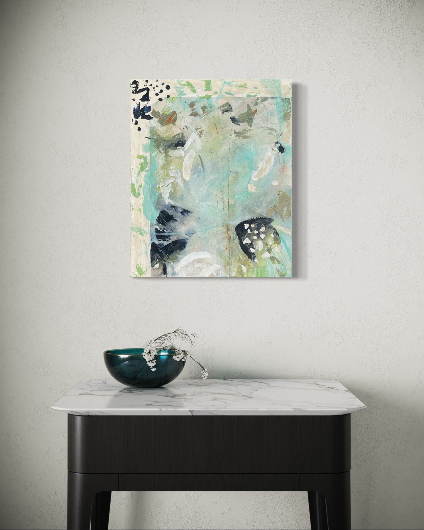 Abstract painting on a wall above a table with a decorative bowl.