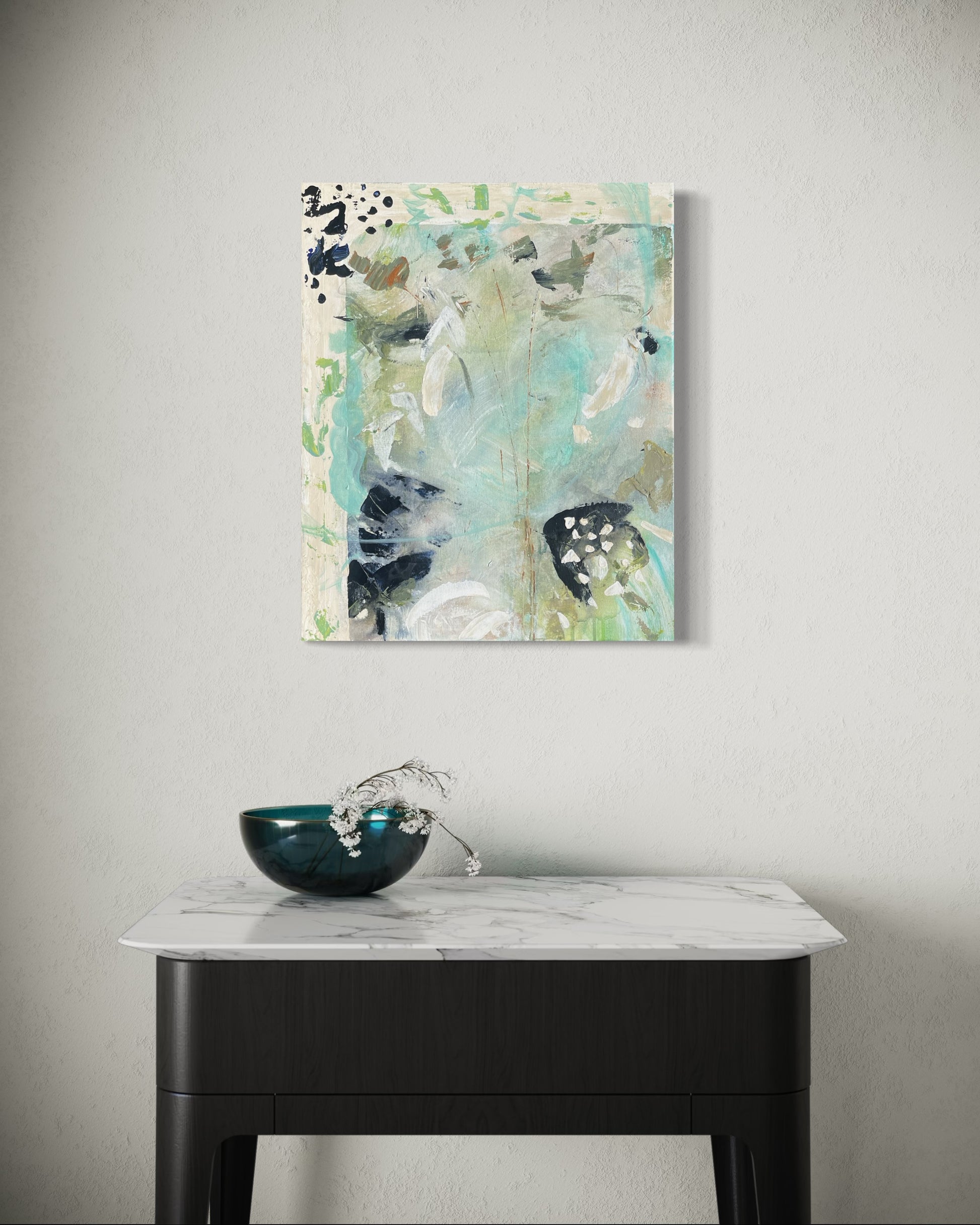 Abstract painting on a wall above a table with a decorative bowl.