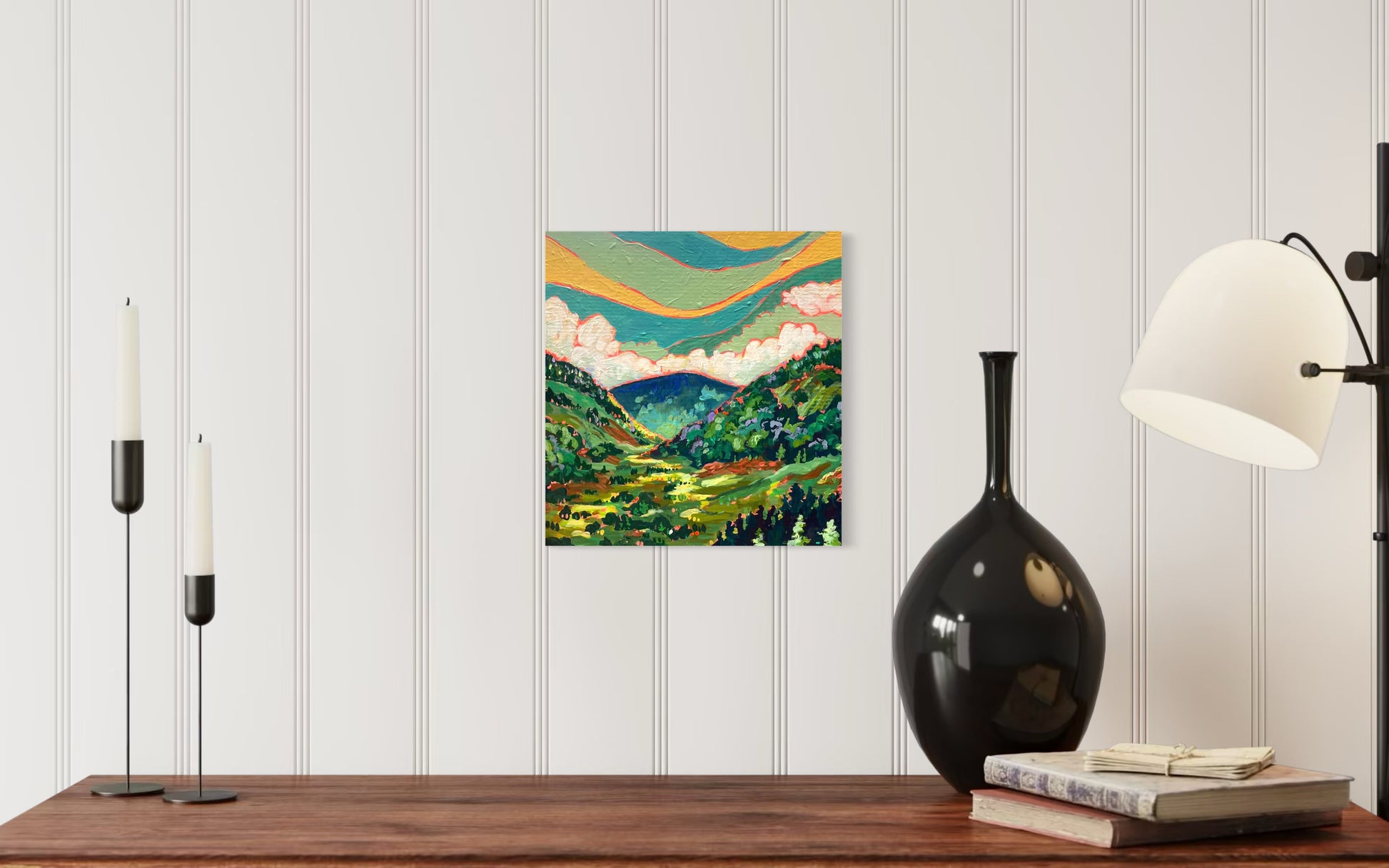 colorful majestic valley acrylic painting by asheville artist erika busse hanging over a table with a vase